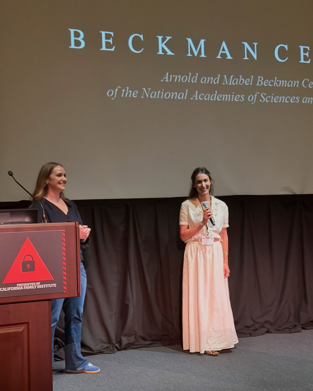 Two presenters with microphones on the Auditorium stage