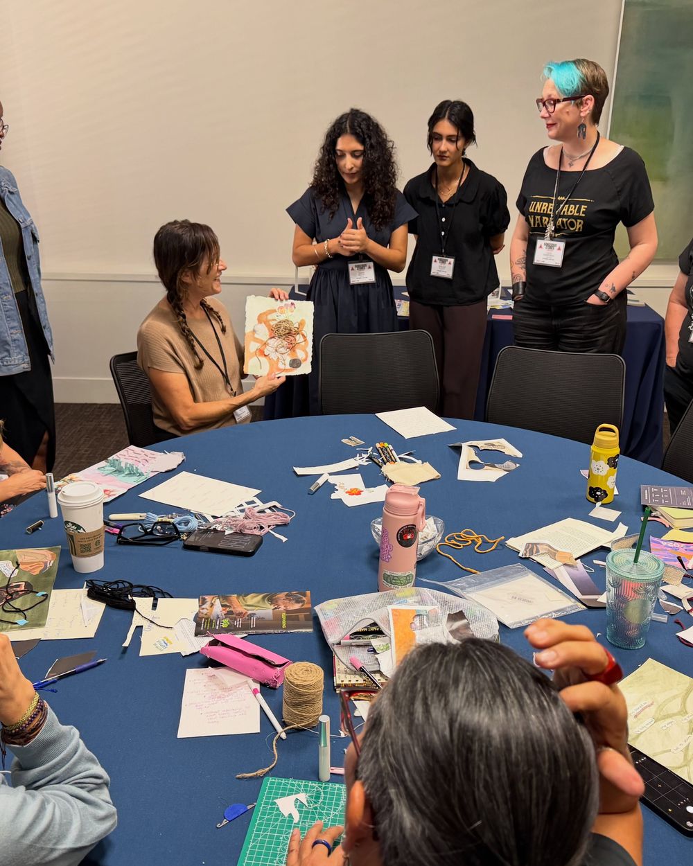 Participants around a table covered with craft and textile materials